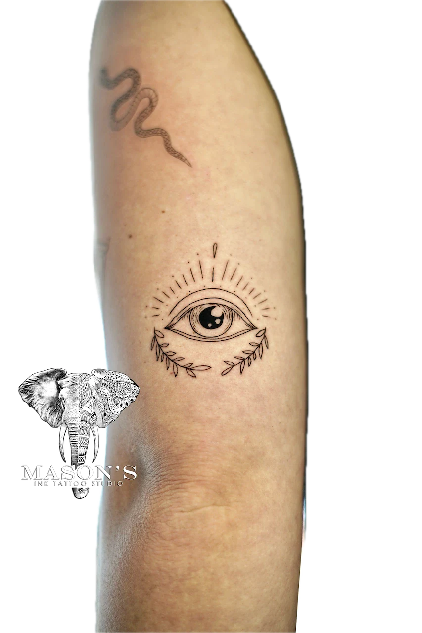 Fine Line Eye Tattoo Design: a minimalist eye with rays and a snake on the forearm