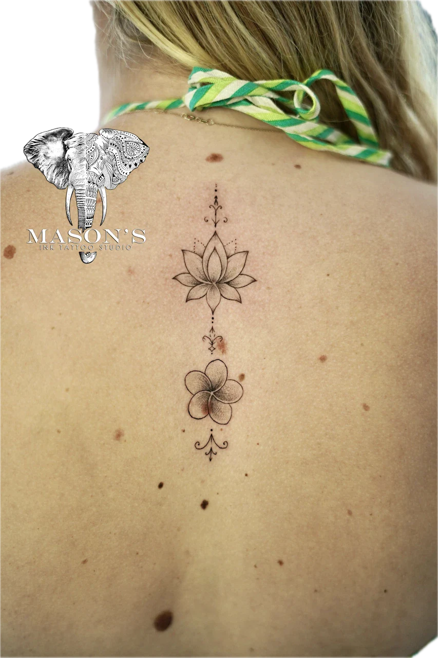 Fine Line Floral Back Tattoo Design: a minimalist line drawing of lotus flowers on the spine