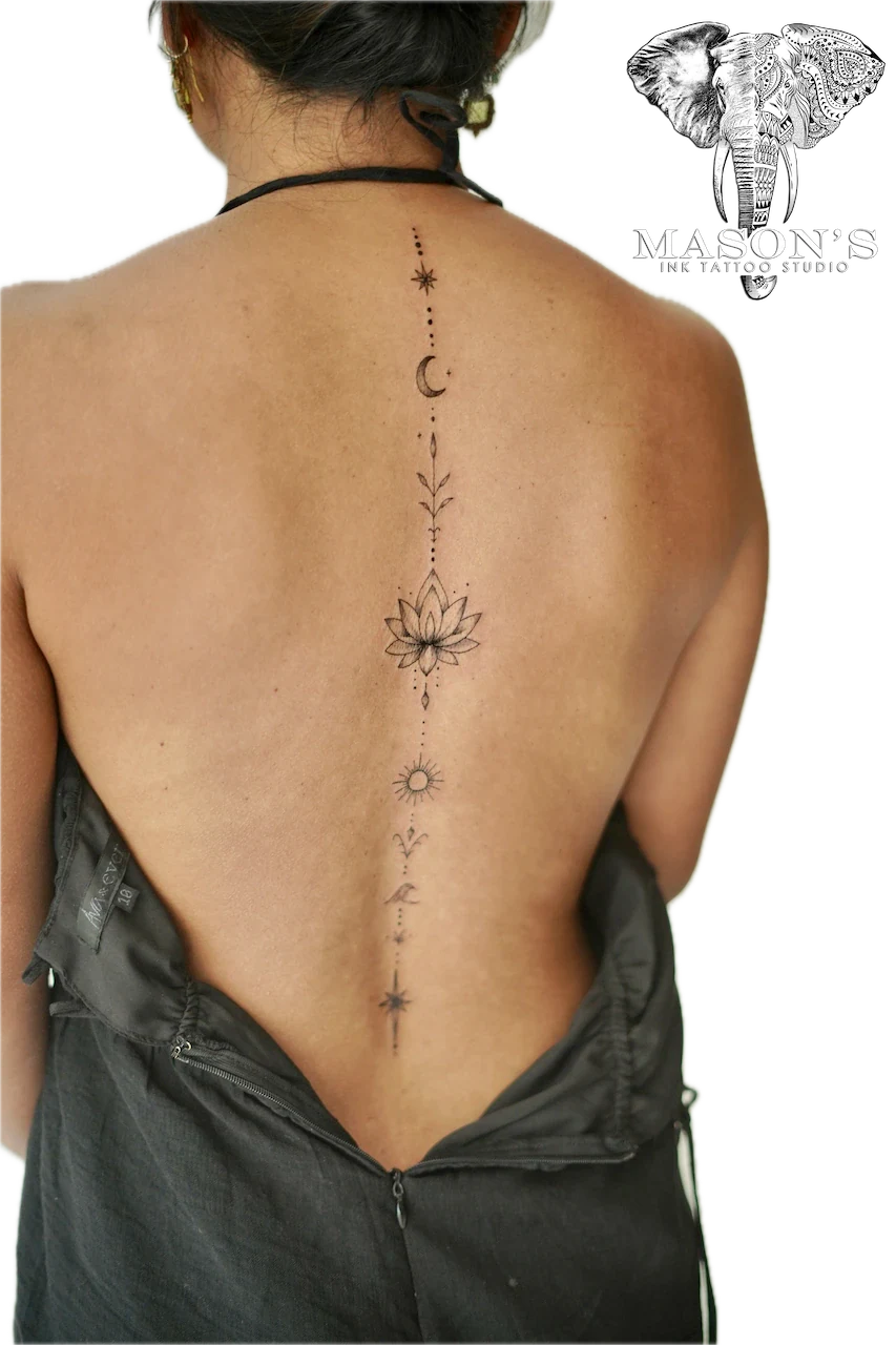 Fine Line Floral Script Tattoo Design: Minimalist line tattoo of a lotus and celestial symbols on the spine