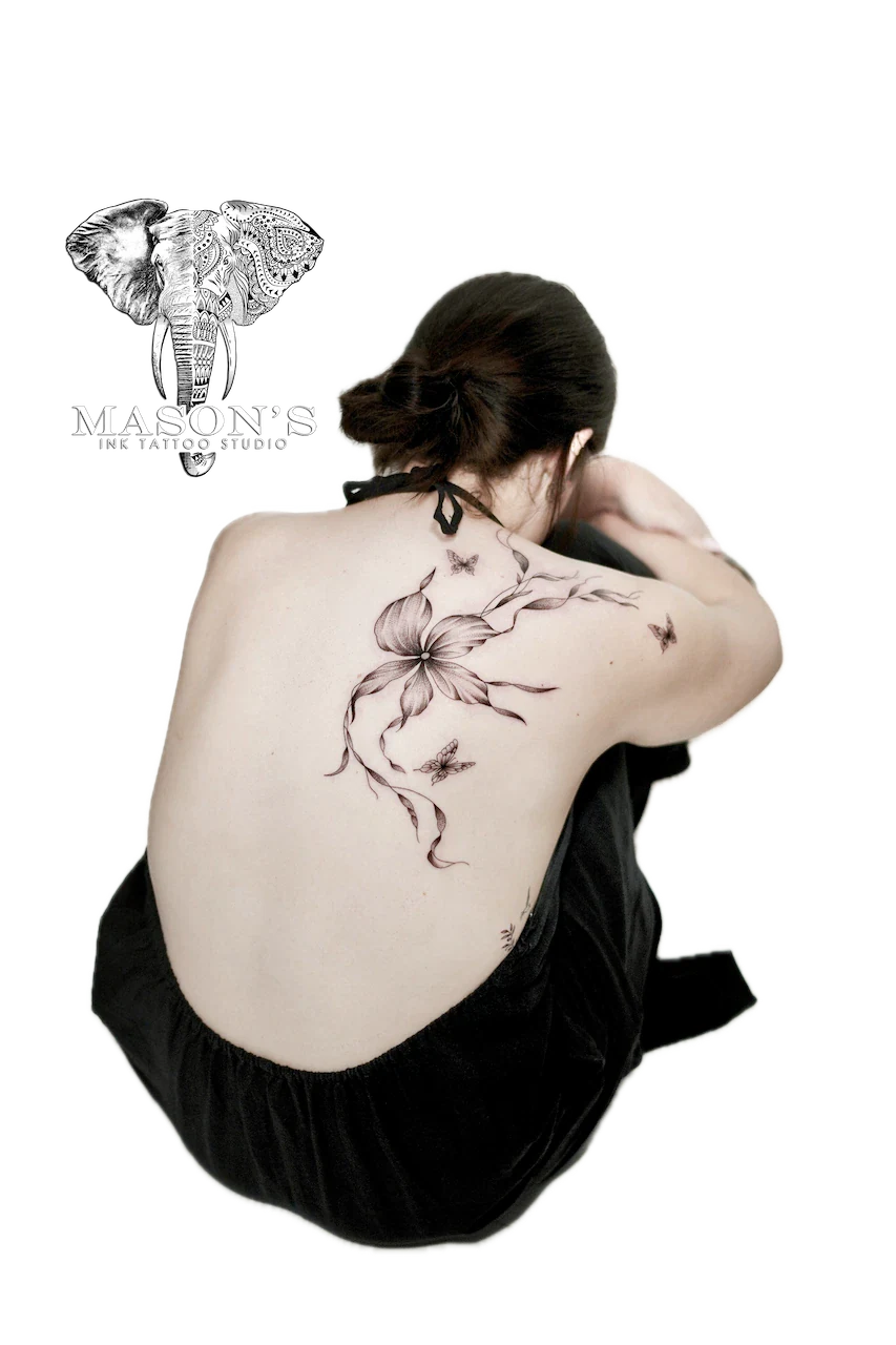 Fine Line Floral Tattoo Design: a large black and grey flower vine with birds on a woman's back