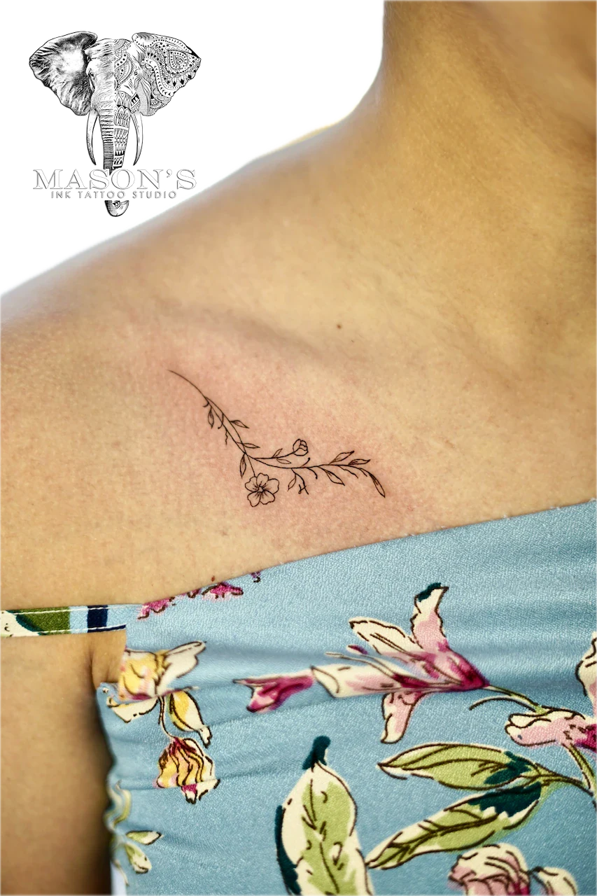 Fine Line Floral Tattoo Design: a small black and grey flower branch on the shoulder