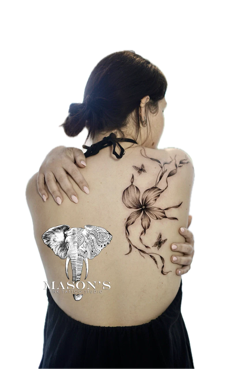 Fine Line Floral Tattoo Design: a large black and grey elephant and flower tattoo on the back