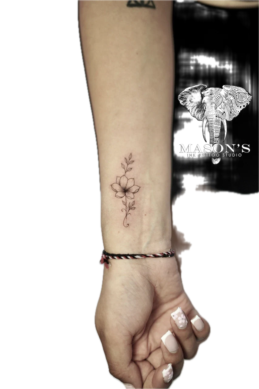 Fine Line Flower Tattoo Design: a delicate black and grey flower tattoo on the forearm