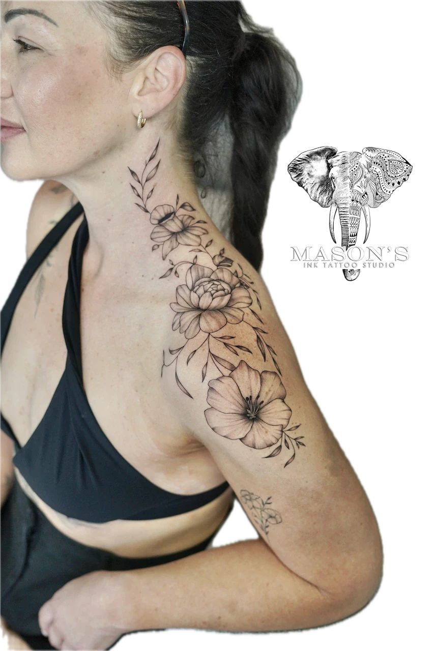Fine Line Flower Tattoo Design: a large floral tattoo with flowers and leaves on the upper arm