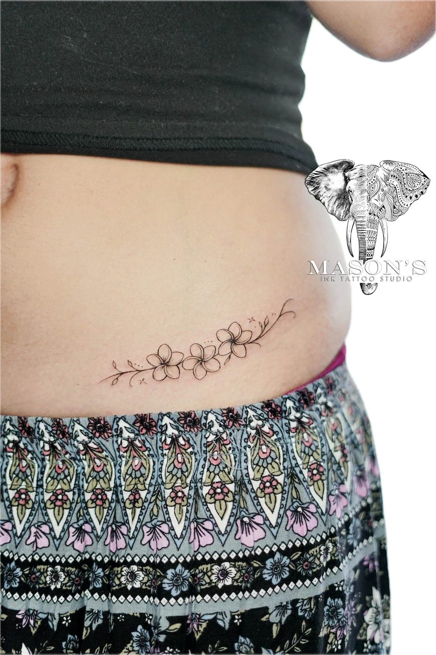 Fine Line Flower Tattoo Design: a delicate floral branch tattoo on the stomach