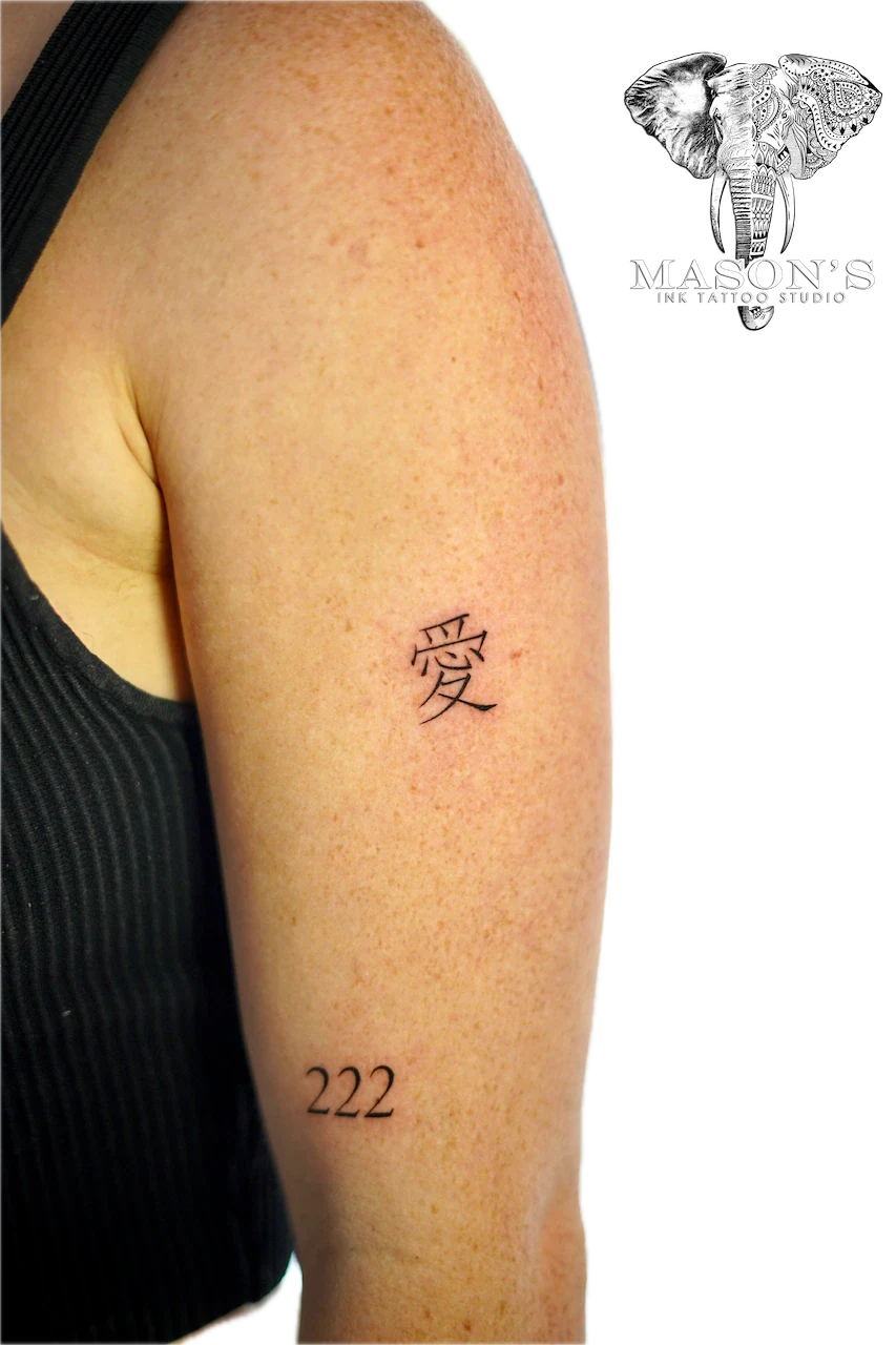 Fine Line Japanese Script Tattoo Design: Small minimalist love lettering and number on upper arm