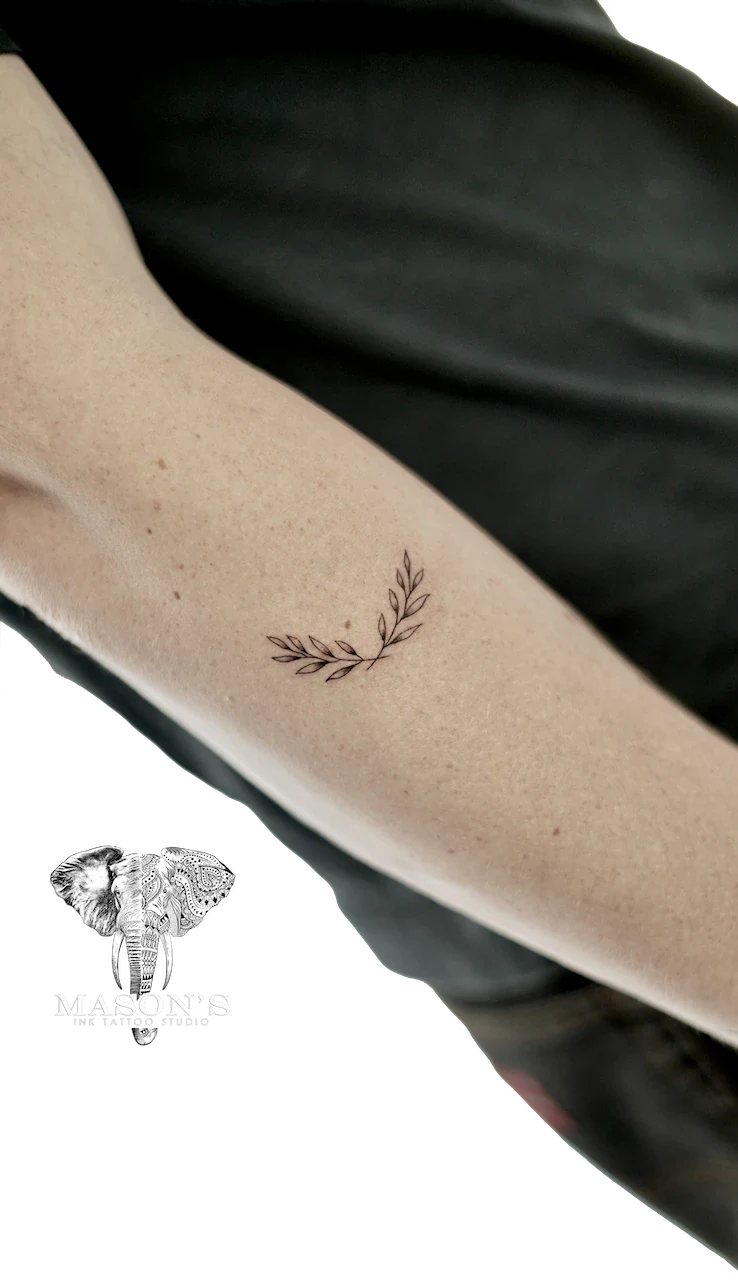 Fine Line Leaf Tattoo Design: a minimal black and grey leaf branch tattoo on the forearm