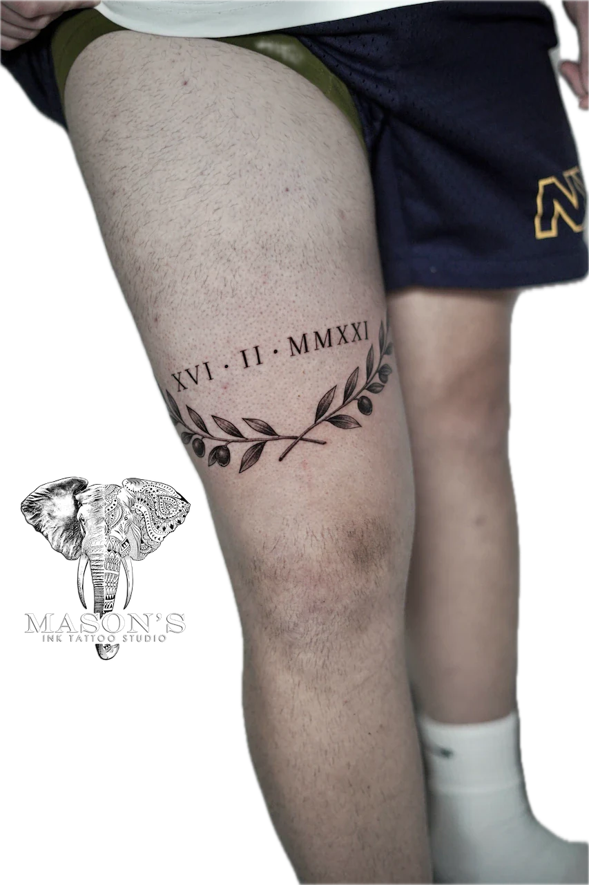 Fine Line Leaf and Script Tattoo Design: Roman numerals and laurel leaves on the thigh