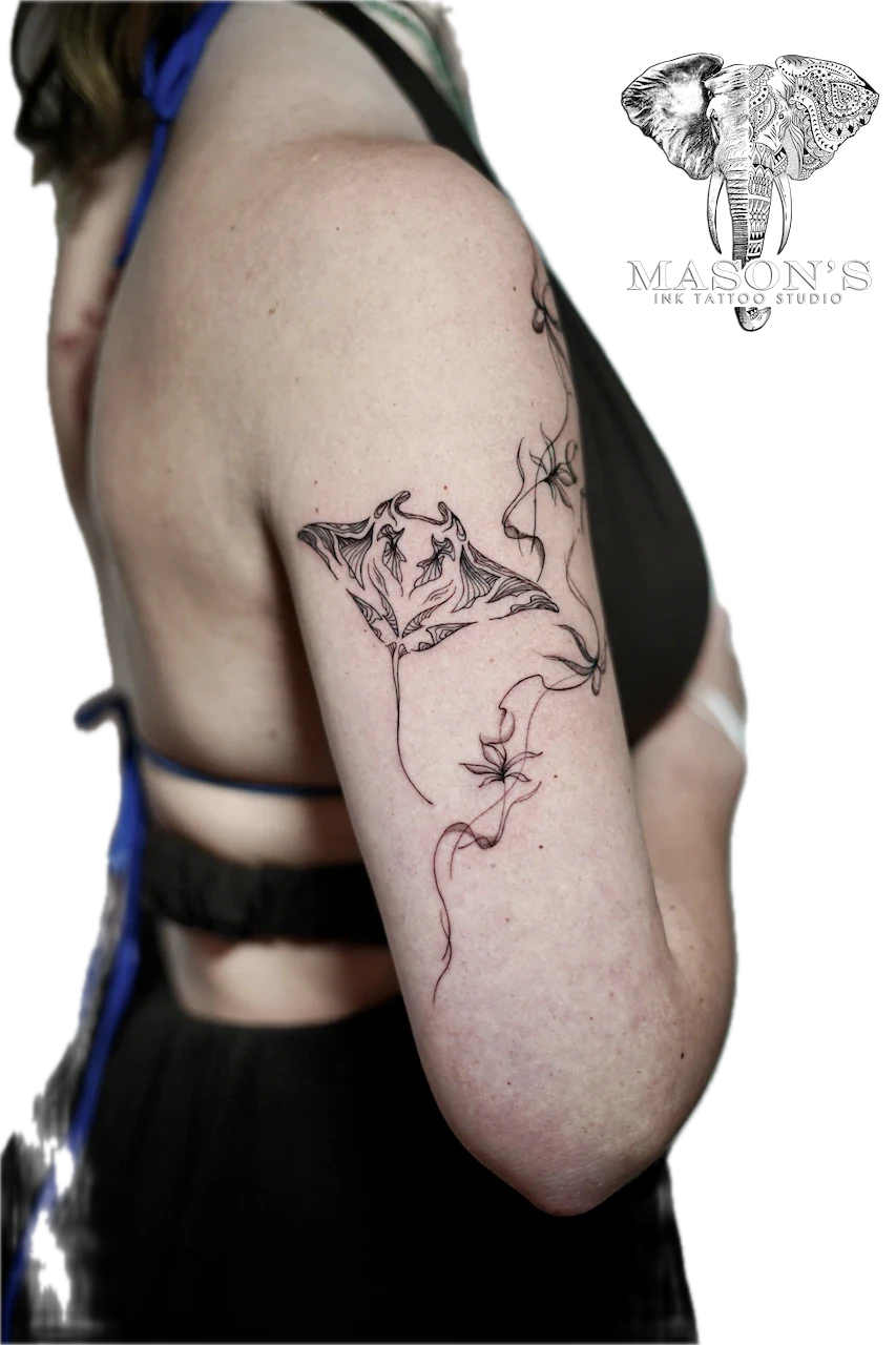 Fine Line Manta Ray Tattoo Design: a minimalist bat and flower design on the upper arm