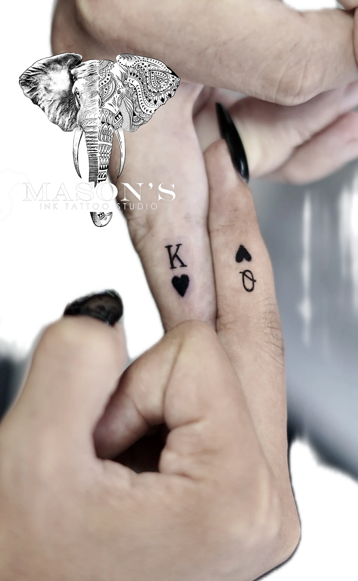 Fine Line King and Queen of Hearts Tattoo Design: Small black and grey playing card lettering on the wrist
