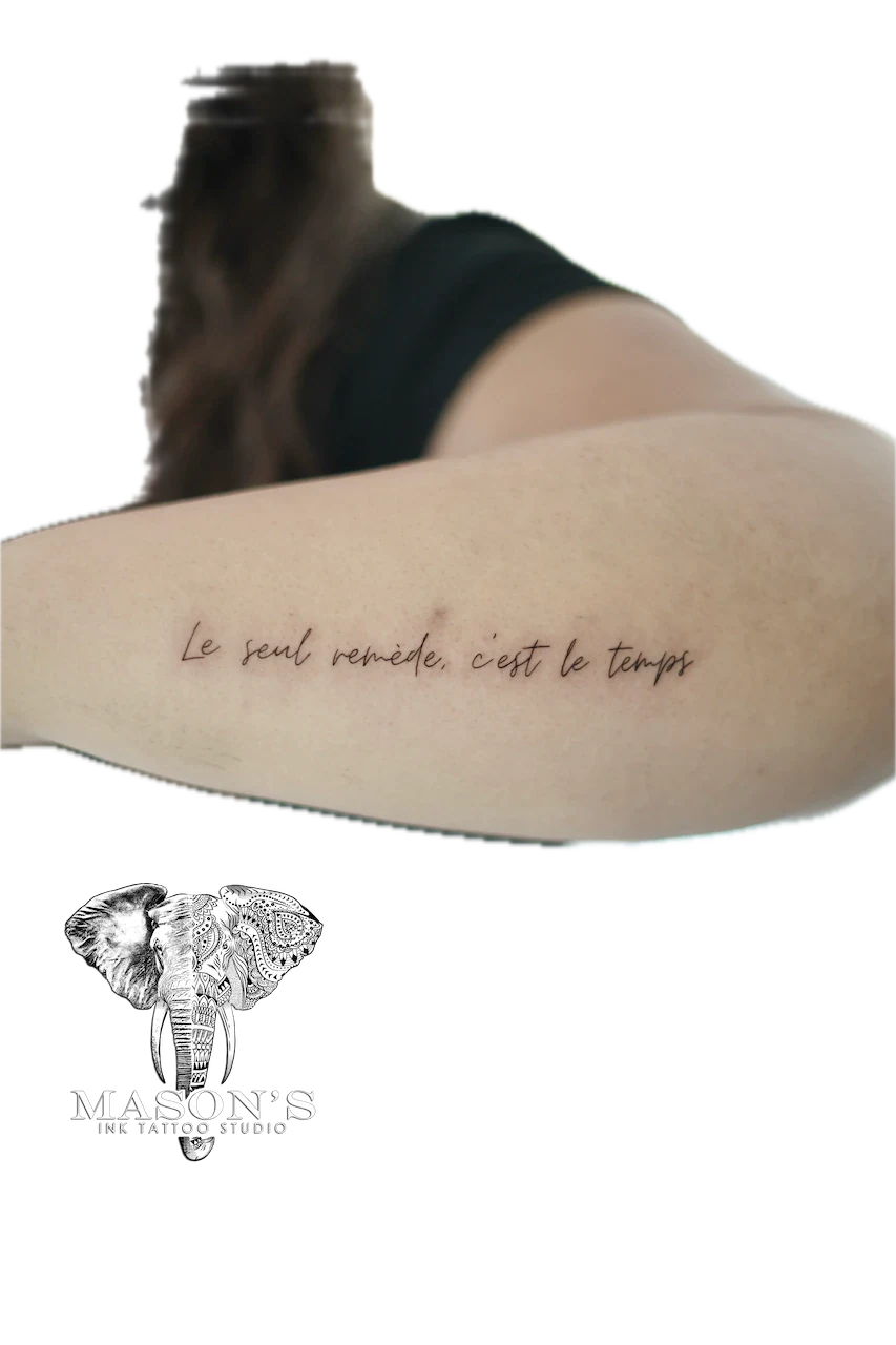 Fine Line Script Arm Tattoo Design: French lettering tattoo on the upper arm