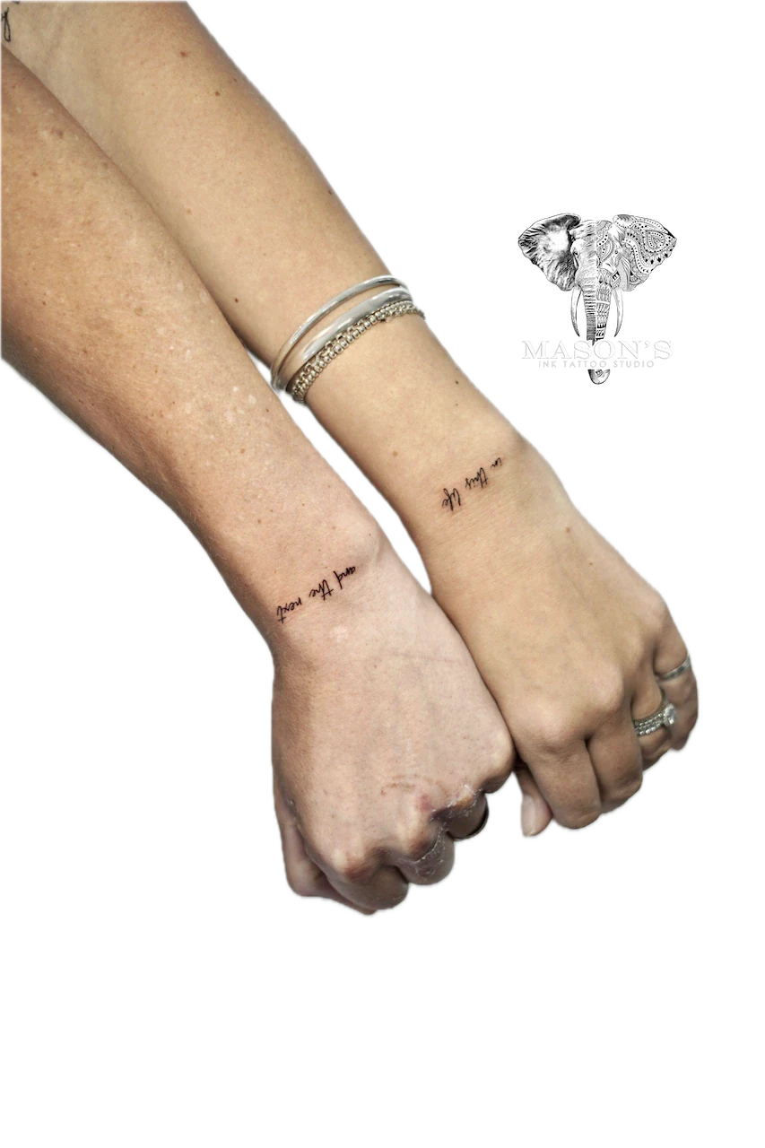 Fine Line Script Hand Tattoo Design: Minimal script lettering on the wrists with jewelry