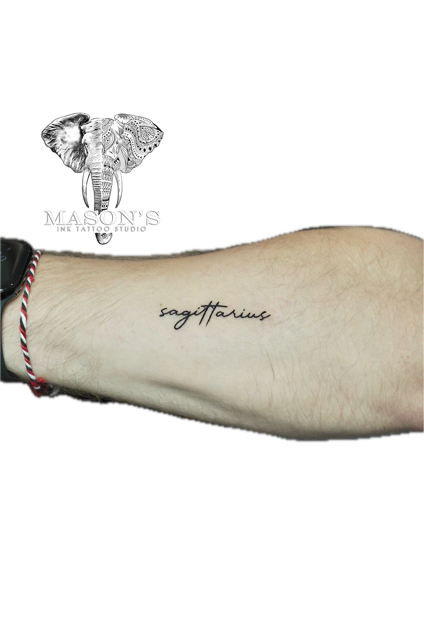 Fine Line Script Tattoo Design: Minimal script lettering of the word Sagittarius on the forearm