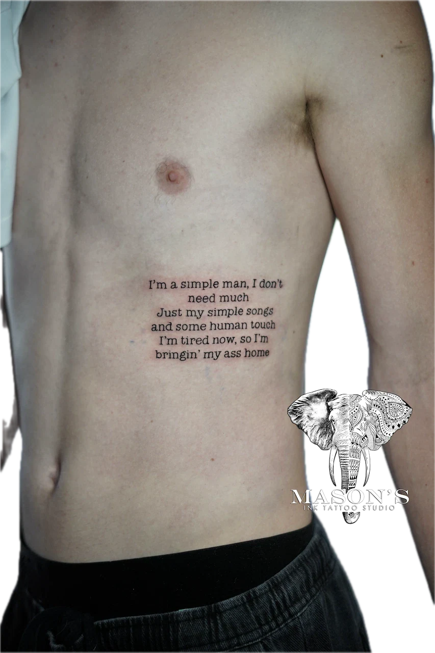 Fine Line Script Tattoo Design: a minimalist elephant and song lyrics on the hip