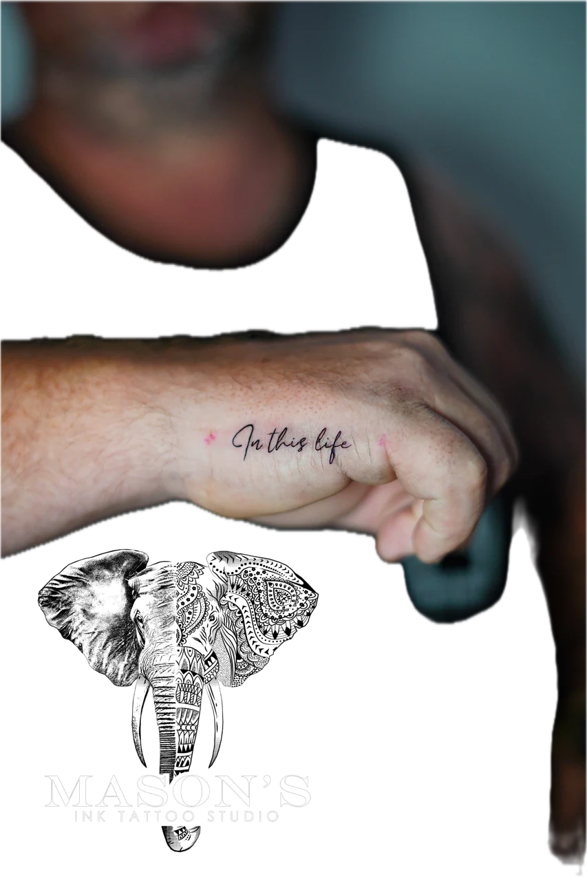 Fine Line Script Tattoo Design: Small black and grey elephant mandala tattoo with lettering on forearm