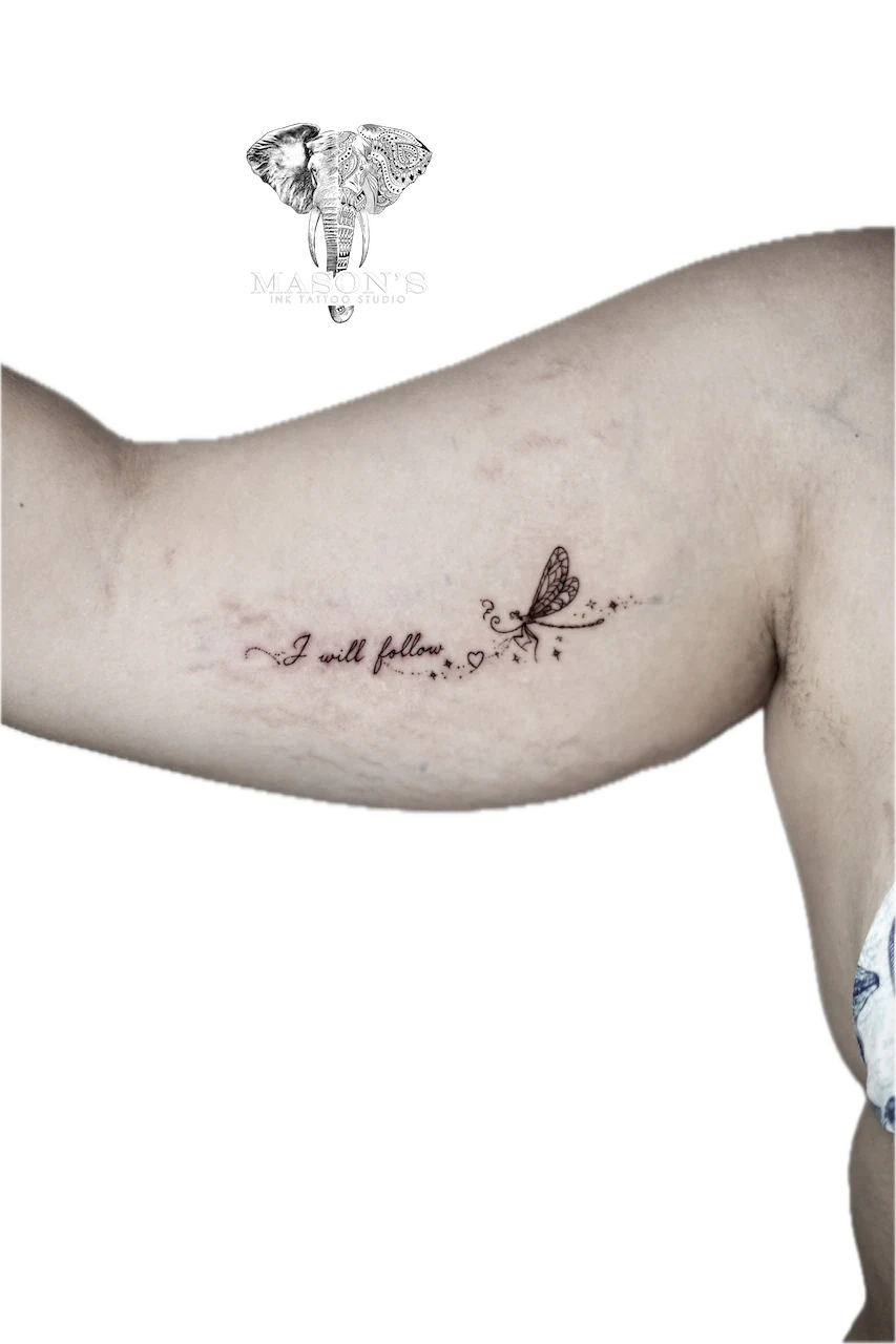 Fine Line Script and Dragonfly Tattoo Design: a small butterfly and hearts with lettering on the upper arm