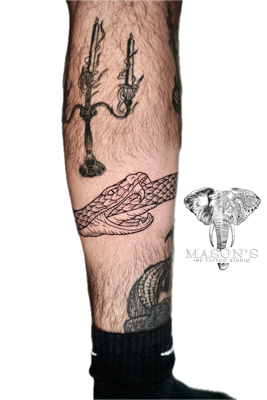 Fine Line Snake Tattoo Design: a large black and grey tattoo of swords, snakes, and mythical creatures on a calf