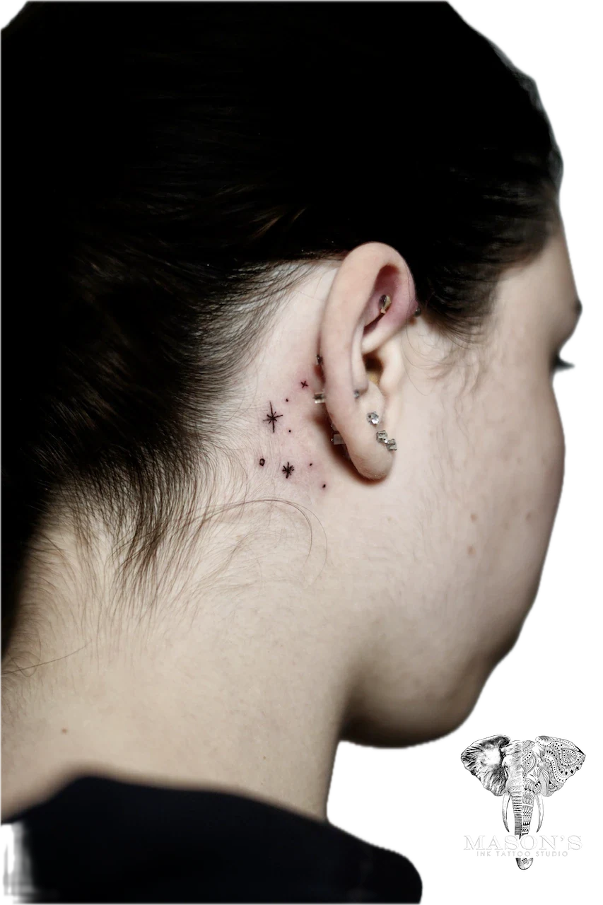 Fine Line Sparkle Tattoo Design: Small stars and dots behind the ear