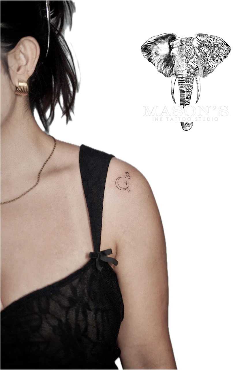 Fine Line Tattoo Style Moon and Star: a small crescent moon with lettering on the upper arm