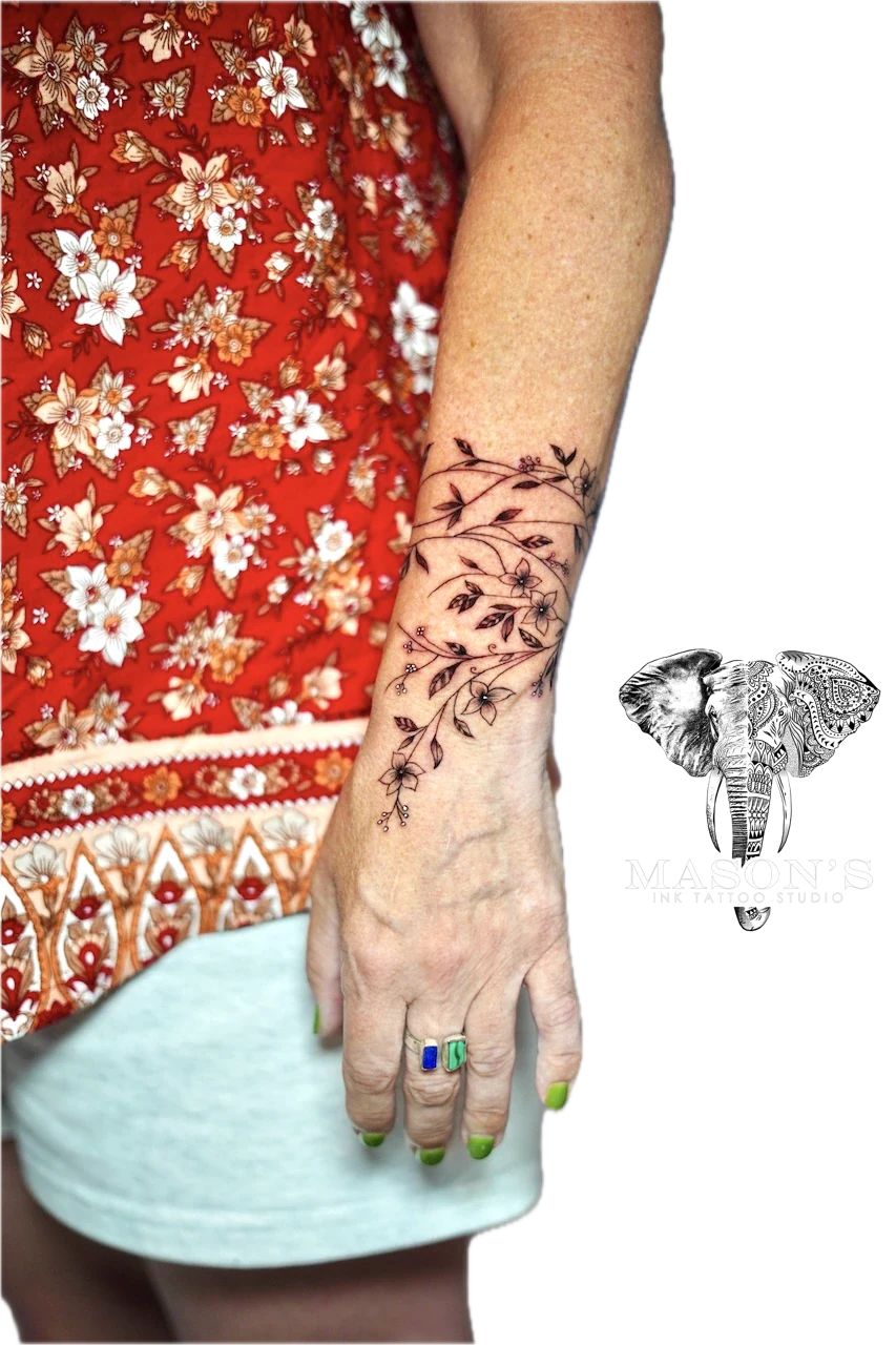 Fineline Floral Tattoo Design: a delicate floral vine tattoo on the forearm