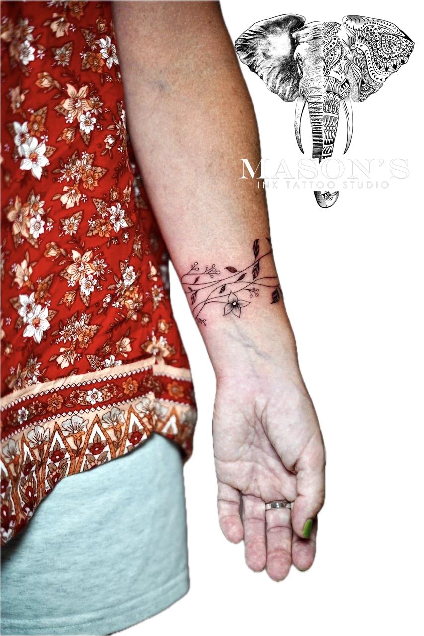 Fineline Floral Tattoo Design: a delicate black and grey floral vine tattoo on the forearm