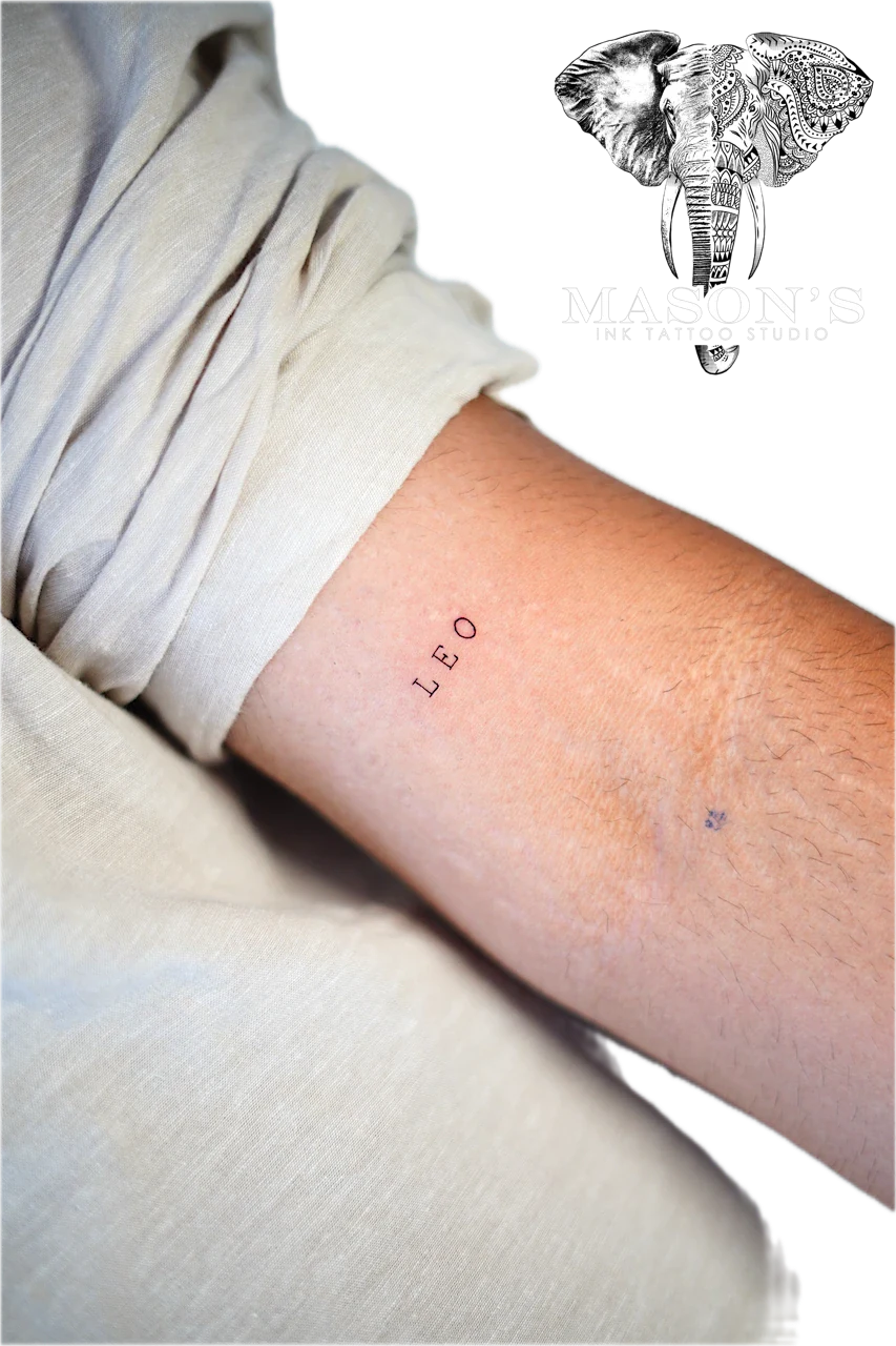 Fineline Script Tattoo Design: Minimal black and grey lettering tattoo on the forearm