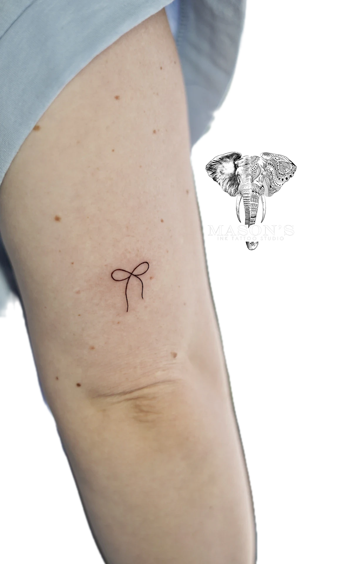 Fine Line Ribbon Tattoo Design: a simple bow tattoo on the thigh