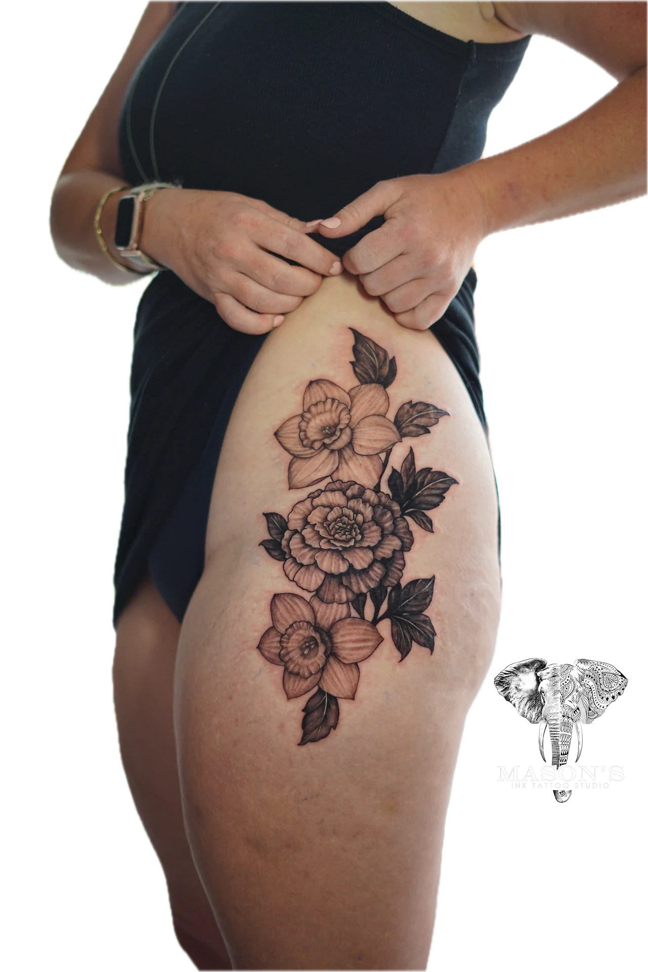 Floral Tattoo Design: a detailed floral tattoo with leaves and buds on the thigh
