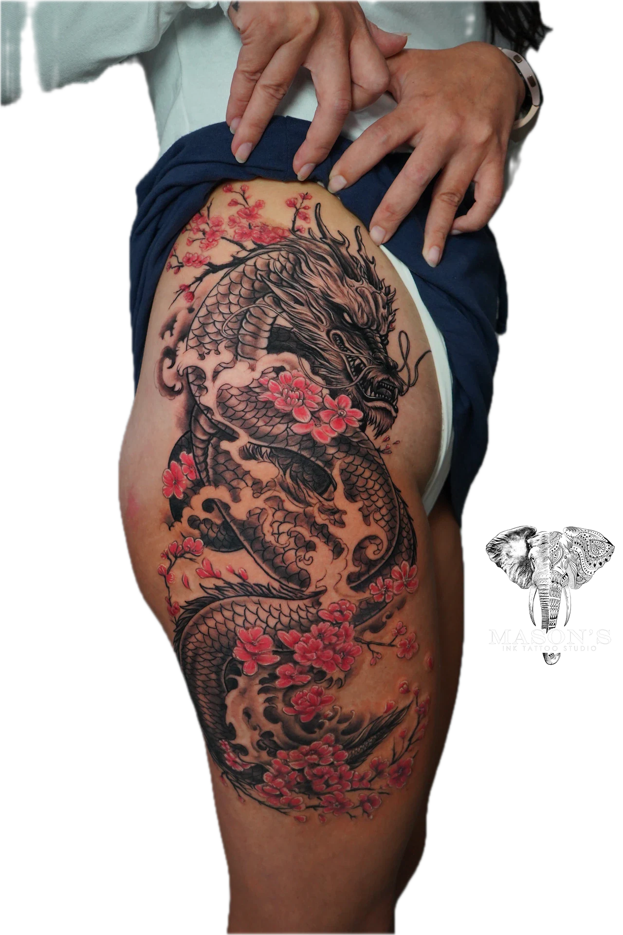 Japanese Dragon Tattoo Design: a large dragon with flowers and clouds on a thigh
