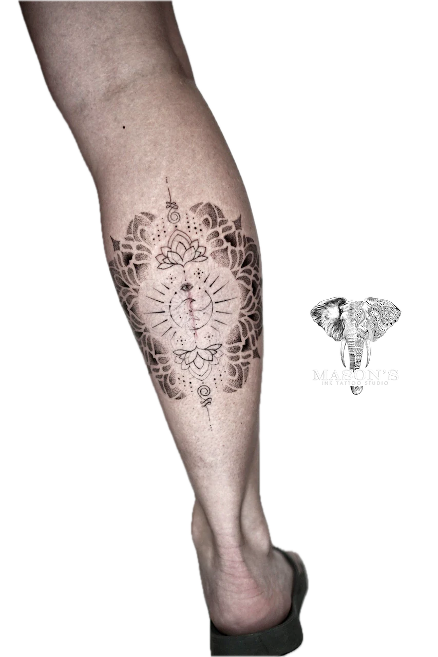 Mandala Tattoo Design: a large black and grey mandala with a lotus and eye on a calf