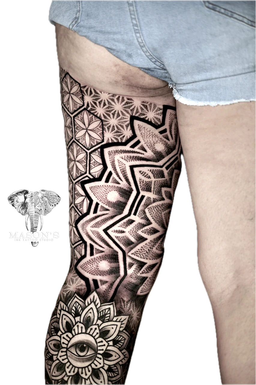 Mandala Tattoo Design: a large black and grey leg tattoo featuring an eye and geometric patterns