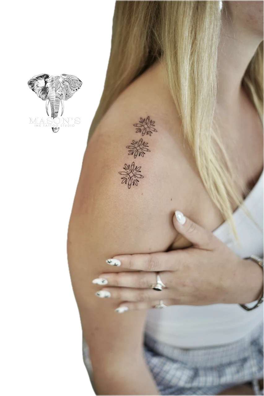 Ornamental Tattoo Design: Three small daisy flowers on the upper arm