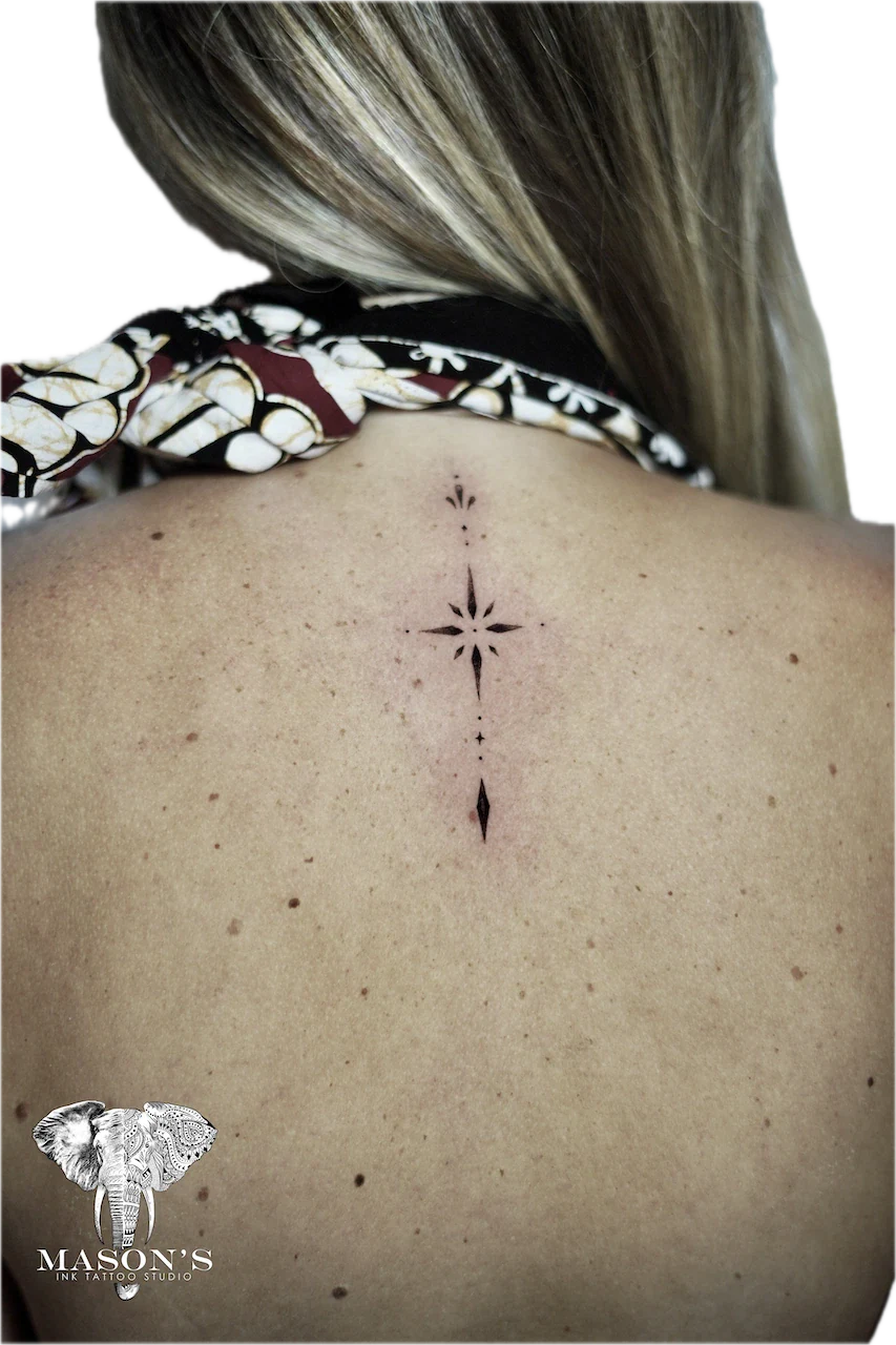 Ornamental Back Tattoo Design: a small star and arrow geometric pattern on the spine