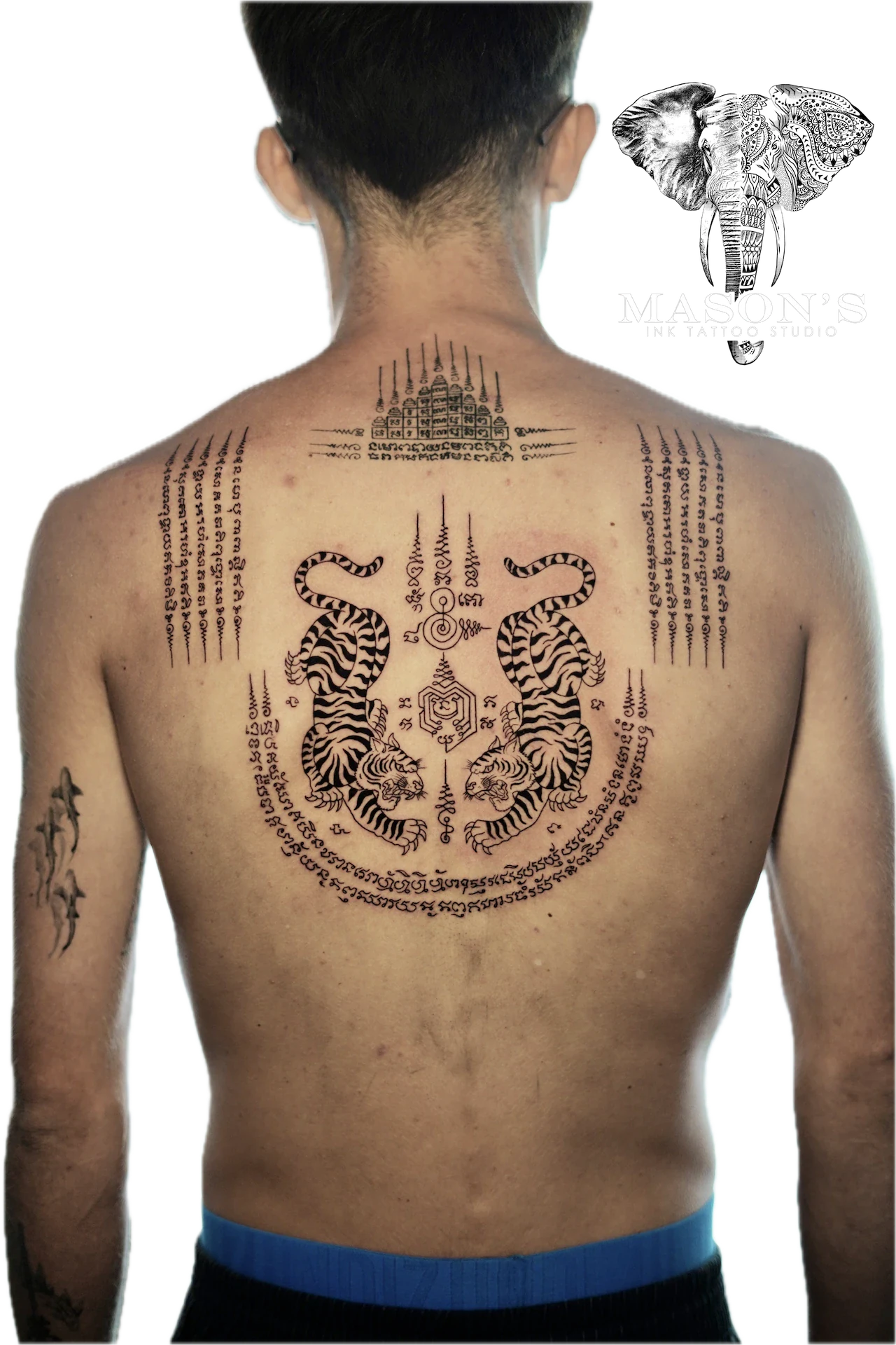 Sak Yant Tattoo Design: a large back tattoo of tigers, lettering, and a temple