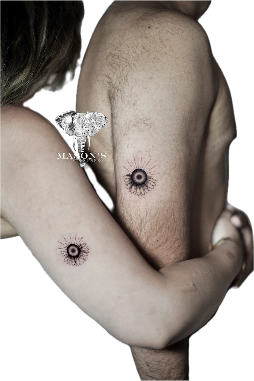 Black and Grey Fine Line Floral Tattoo Design: Minimalist elephant and flower tattoos on the upper arm